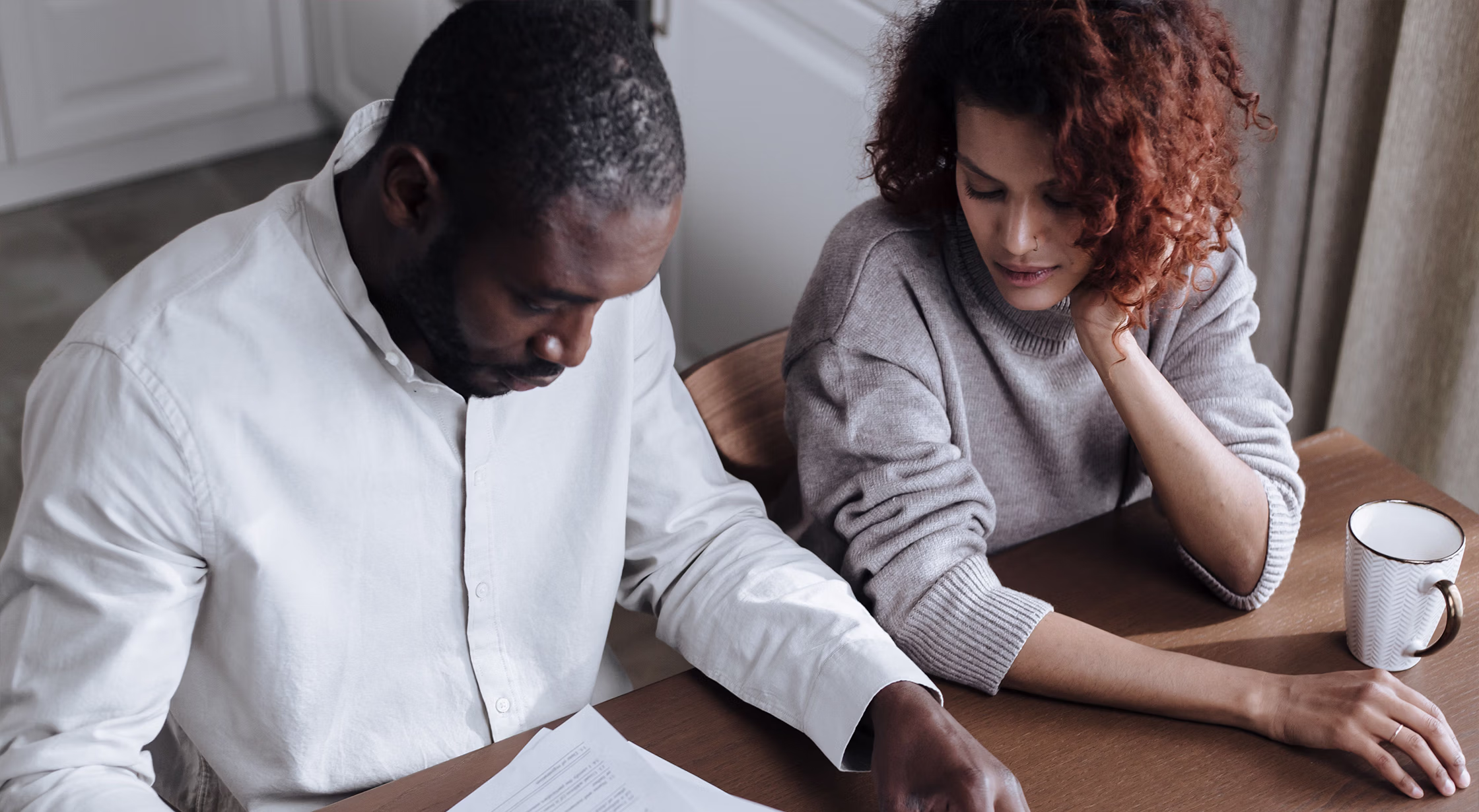 Two adults reviewing home and financial documents during a divorce